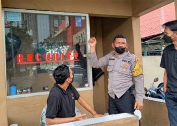 Personil Polsek Medan Menempelkan Stiker Pengaduan. (Foto Ist)