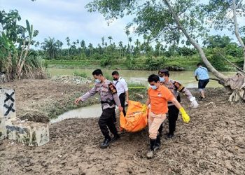 Pihak Kepolisian saat evakuasi jasad pria tanpa identitas dari lokasi kejadian