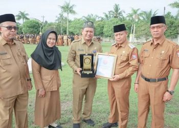 Wali Kota Tanjungbalai H. Waris Thalib menyerahkan Piagam Penghargaan kepada Pelaksana tugas (Plt) Kepala Dinas Kominfo Informatika (Kadiskominfo), Andrinuka Saptana