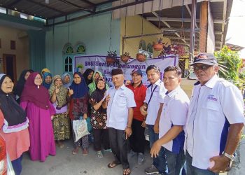 pengurus SMSI Siantar - Simalungun foto bersama dengan warga penerima bantuan.