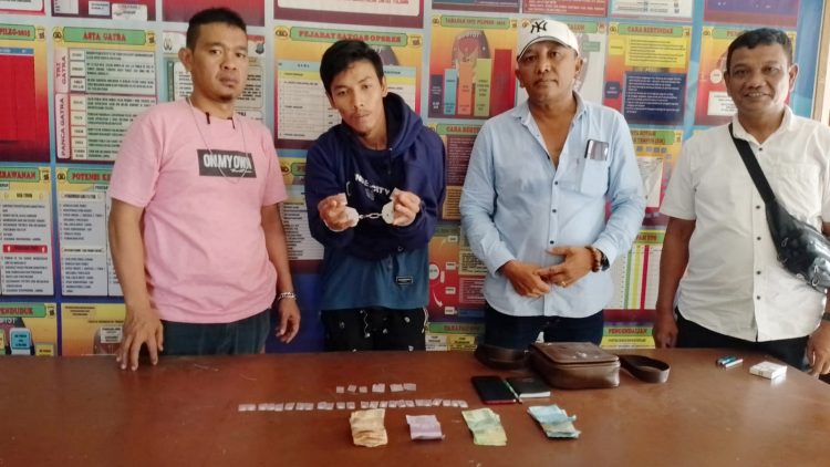 Pelaku Bayu Isna Irsani dan barang bukti diapit polisi