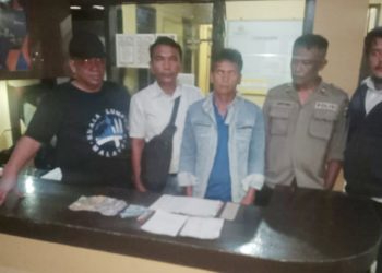 Kapolsek Raya AKP Alwan bersama personil mengapit pelaku judi Jhon Hitler Sijabat dan barang bukti