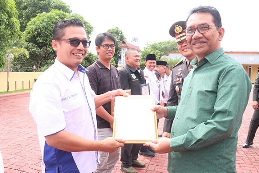 Ketua SMSI Siantar Simalungun, Rivay Bakkara menerima Piagam Penghargaan yang diserahkan Ketua DPRD Simalungun Timbul Jaya Sibarani didampingi Kapolres Simalungun AKBP Ronald F.C Sipayung SH, SIK, MH