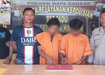 Kedua pelaku, RW dan N beserta barang bukti diapit polisi