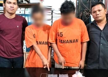 Kedua pelaku RA dan AV beserta barang bukti diapit polisi
