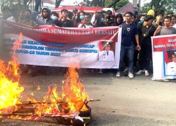 Ratusan mahasiswa mengelar aksi dengan membakar keranda mayat dan mendesak agar mantan Bupati Samosir Rapidin Simbolon terkait kasus dugaan korupsi dana Covid-19. (Foto Ist)