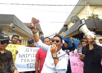 Dwi Ngai Sinaga bersama sejumlah advokat saat berunjuk rasa di halaman Polrestabes Medan dengan aksi tearikal uang. (Foto Ist)