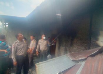 Personil Polsek Siantar Marihat saat olah TKP di rumah milik Wilson Simanjuntak yang terbakar