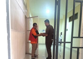 Terdakwa RJP, oknum pendeta saat mau digiring petugas pengawal tahanan (Walta) Kejari Siantar masuk ke ruangan sidang (Foto Ist/Dokumen)