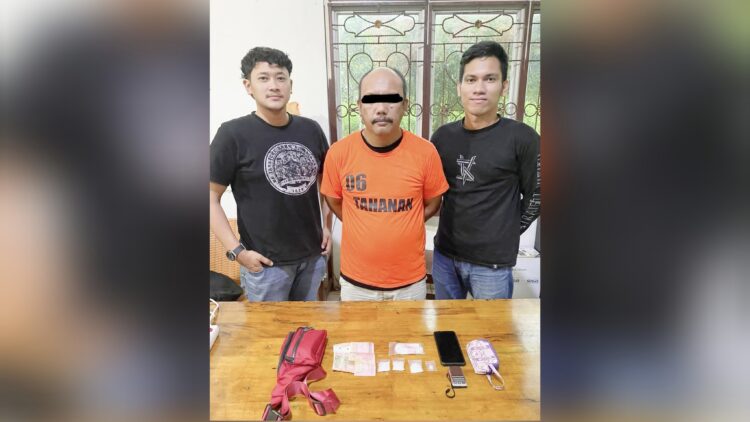 Tersangka RR alias Tunggul diapit Polisi