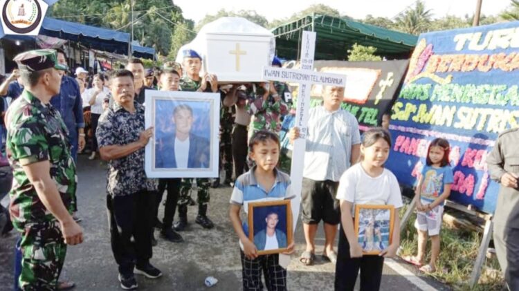 Personil Pomal Lanas Nias mengangkat peti jenazah almarhum Iwan Sutrisman Telaumbanua untuk dimakamkan. (Foto ist)