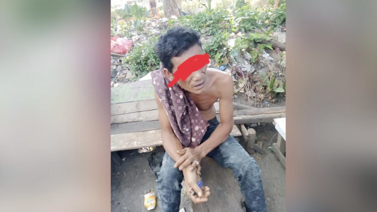 Pelaku Penganiayaan, JS yang ditangkap lagi duduk santai dibelakang rumahnya.