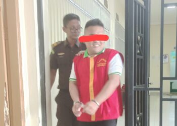 Terdakwa Hoddy Nata saat dikawal petugas Pengawal tahanan (Walta) Kejari Siantar