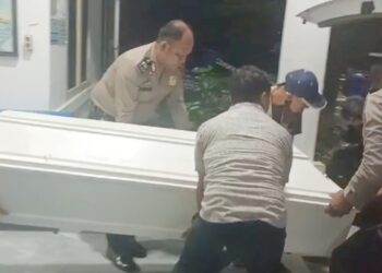 Kapolsek Siantar Timur IPTU Jon H. Purba bersama personil bantu masukkan peti jenajah korban Hendarso Tri Widyanto ke ambulan untuk diberangkatkan ke rumah keluarganya di Semarang