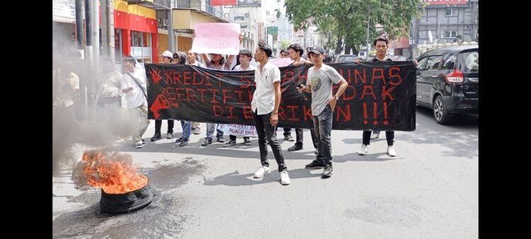 Puluhan massa mengelar aksi dengan membakar ban di depan BTN KC Medan, Jln.Pemuda, Medan. (Foto Ist)