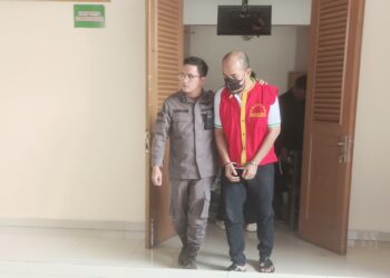 Terdakwa Putra A Sitompul SE saat digiring petugas pengawal tahanan usai disidangkan. (Dokumen)