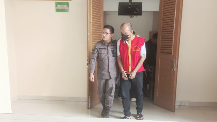 Terdakwa Putra A Sitompul SE saat digiring petugas pengawal tahanan usai disidangkan. (Dokumen)