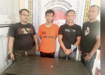 Tersangka Reza Fahlevi Saragih diapit polisi