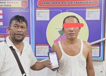 pelaku judi Richard Pahotan Hutapea menunjukkan barang bukti