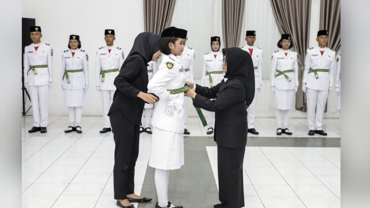 dr Susanti secara simbolis menyematkan lencana dan pemasangan kendit kepada Pemimpin Upacara Hanna Theresya Simamora