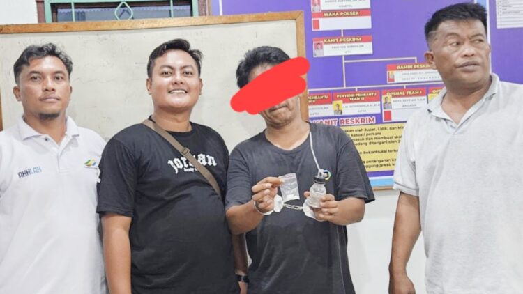 Pelaku Hozion Hengky Siahaan alias Hozion menunjukkan barang bukti diapit Tim Unit Reskrim Polsek Tanah Jawa