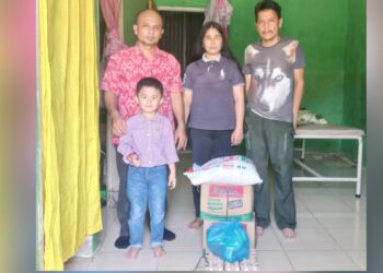 Warga Tanjung Anom, Dameria Zega menerima bantuan sembako dari Calon Bupati Deli Serdang, H. Asri Ludin Tambunan diwakili Humas Re-Born Romulo Sinaga didampingi warga di Perumahan Grand Permata Residence 2 Tanjung Anom, Deli Serdang. (Foto Ist)