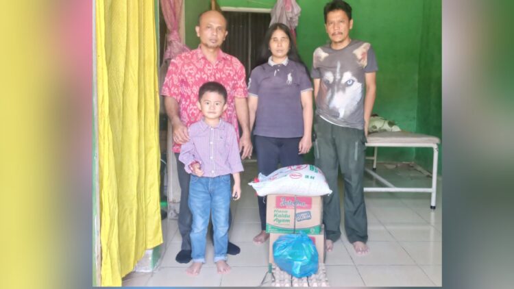 Warga Tanjung Anom, Dameria Zega menerima bantuan sembako dari Calon Bupati Deli Serdang, H. Asri Ludin Tambunan diwakili Humas Re-Born Romulo Sinaga didampingi warga di Perumahan Grand Permata Residence 2 Tanjung Anom, Deli Serdang. (Foto Ist)