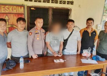 Kapolsek Bosar Maligas IPTU Sonni G. Silalahi SH dan anggota mengapit Tersangka RS beserta barang bukti