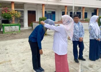 Kepala Sekolah SMP Negeri 1 Kota Tebing Tinggi, Paini S.Pd, MP.d menyerahkan Penghargaan kepada guru dan siswa siswi
