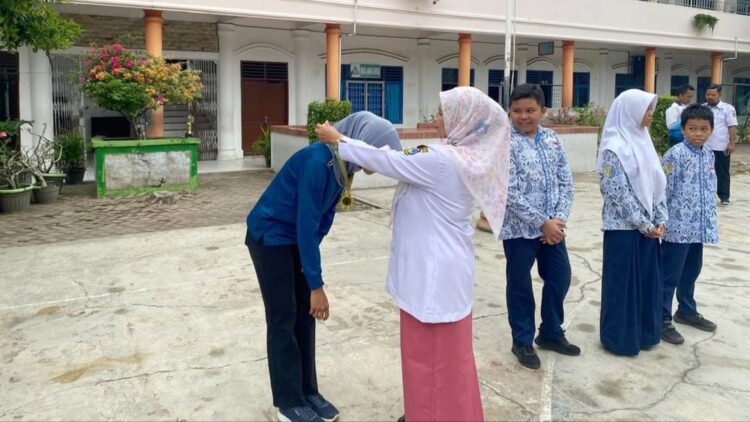 Kepala Sekolah SMP Negeri 1 Kota Tebing Tinggi, Paini S.Pd, MP.d menyerahkan Penghargaan kepada guru dan siswa siswi