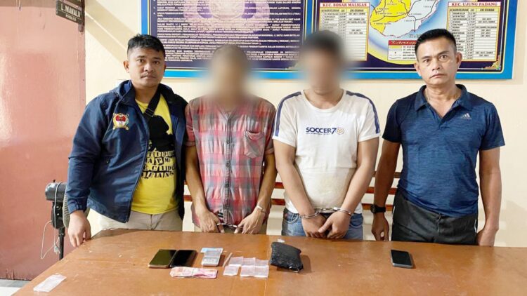 Kapolsek Bosar Maligas IPTU Sonni G Silalahi mengapit kedua pengedar, AS dan EK beserta barang bukti