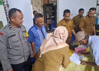 Bhabinkamtibmas Polsek Bosar Maligas, Aiptu J.S. Butar Butar melaksanakan monitoring penyaluran Bantuan Langsung Tunai (BLT) di Kantor Pangulu Nagori Banjar Hulu