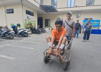 Tersangka AS residivis curanmor dihadirkan dengan diangkut menggunakan Trolly barang saat press release di Polsek Sunggal. (Foto Ist)