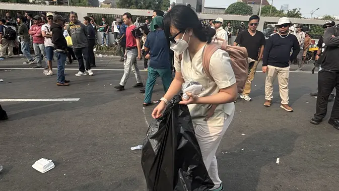 Pemuda Memungut Sampah di Tengah Aksi Massa