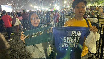 Warga Serbu Monas Berebut Handuk Kaus di Karnaval Malam Merdeka