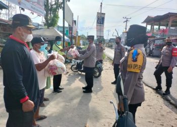 Waka Polres Asahan dan personil pada kegiatan bagi sembako penarik minat pedagang ikuti vaksinasi di Pajak Tradisional Dusun II Desa Bandar Pasir Mandoge