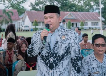 Kepala SMKN 1 Barumun Bidarlis Nur Ibrahim Rangkuti saat menyampaikan sambutannya dalam pembagian rapor semester ganjil Tahun Pelajaran 2025/2026, yang dihadiri orang tua/wali murid, guru, dan tenaga kependidikan, Jumat (19/12/2025).