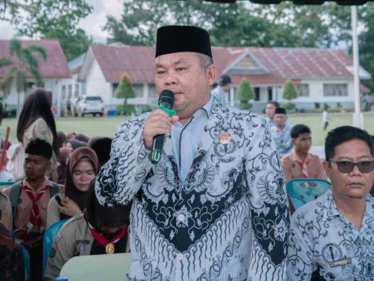 Kepala SMKN 1 Barumun Bidarlis Nur Ibrahim Rangkuti saat menyampaikan sambutannya dalam pembagian rapor semester ganjil Tahun Pelajaran 2025/2026, yang dihadiri orang tua/wali murid, guru, dan tenaga kependidikan, Jumat (19/12/2025).
