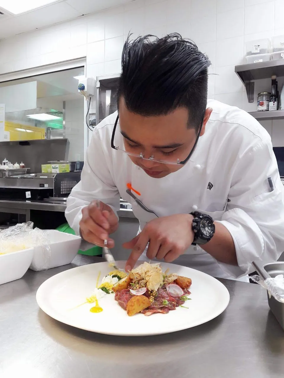 Chef Bobby Sutanto plating a dish in a hotel kitchen