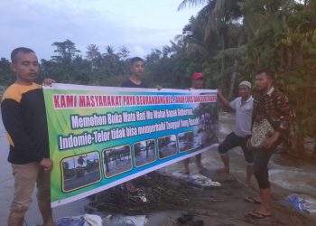 Warga Paya Beurandang membentangkan spanduk permintaan kepada Pemerintah agar melakukan perbaikan terhadap tanggul