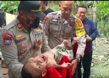 Kasat Binmas Polres OKI, Iptu Bambang, menggendong penderita lumpuh layu, Marlina dan Senen, warga desa Awal Terusan, Kecamatan SP. Padang