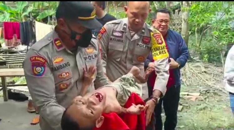 Kasat Binmas Polres OKI, Iptu Bambang, menggendong penderita lumpuh layu, Marlina dan Senen, warga desa Awal Terusan, Kecamatan SP. Padang