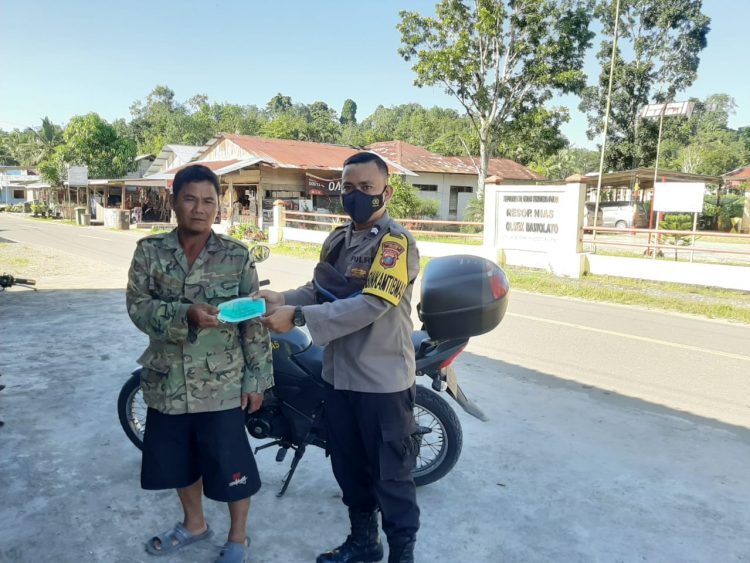 Bhabinkamtibmas Polsek Bawolato Polres Nias Briptu Sahat P. Manik, melakukan kegiatan pembagian Masker Gratis