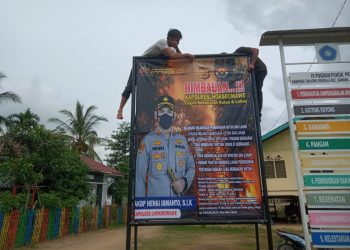 Personel Polsek Sawang memasang spanduk sosialisasi pencegahan kebakaran hutan dan lahan (karhutla) di Gampong Tanjong Keumala