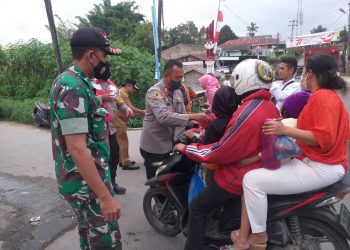 Kapolsek Sidikalang Kota AKP Sukanto Berutu, SH membagikan Bendera Merah Putih kepada masyarakat yang mengendarai kenderaan di jalan Sidikalang - Tigalingga KM 2