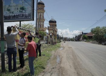 Personel Sat Lantas Polres Lhokseumawe memasang spanduk himbauan di empat titik kawasan rawan kecelakaan lalu lintas