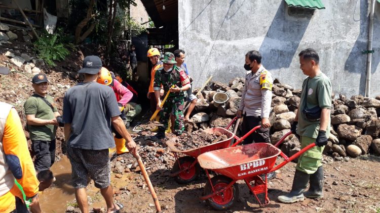 Kapolsek Purwokerto Utara Kompol Sudigdo Mamboro, SH bersama Bhabinkamtibmas Aipda Deni Yulianto dan unsur terkait melaksanakan kegiatan kerja bakti bersama warga membersihkan puing-puing tanah longsor