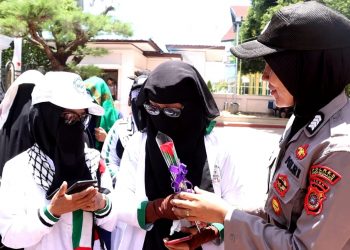 Polisi Wanita (Polwan) Polres Lhokseumawe yang ikut mengamankan demo tersebut sukses mencairkan dan membuat adem suasana dengan membagikan bunga kepada peserta aksi