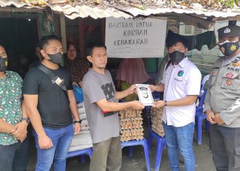 Kanit Idik II Satuan Reserse Narkoba, Ipda Sujiwo S Pramono dan Tim, menyerahkan bantuan sosial (Bansos) kepada keluarga korban kebakaran rumah di Jalan Sirandorung