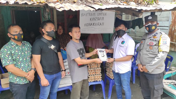 Kanit Idik II Satuan Reserse Narkoba, Ipda Sujiwo S Pramono dan Tim, menyerahkan bantuan sosial (Bansos) kepada keluarga korban kebakaran rumah di Jalan Sirandorung